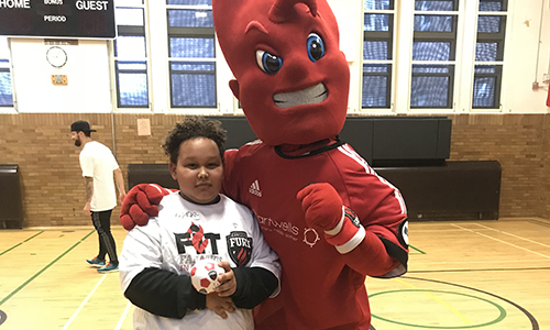Fury mascot posing with a young fan